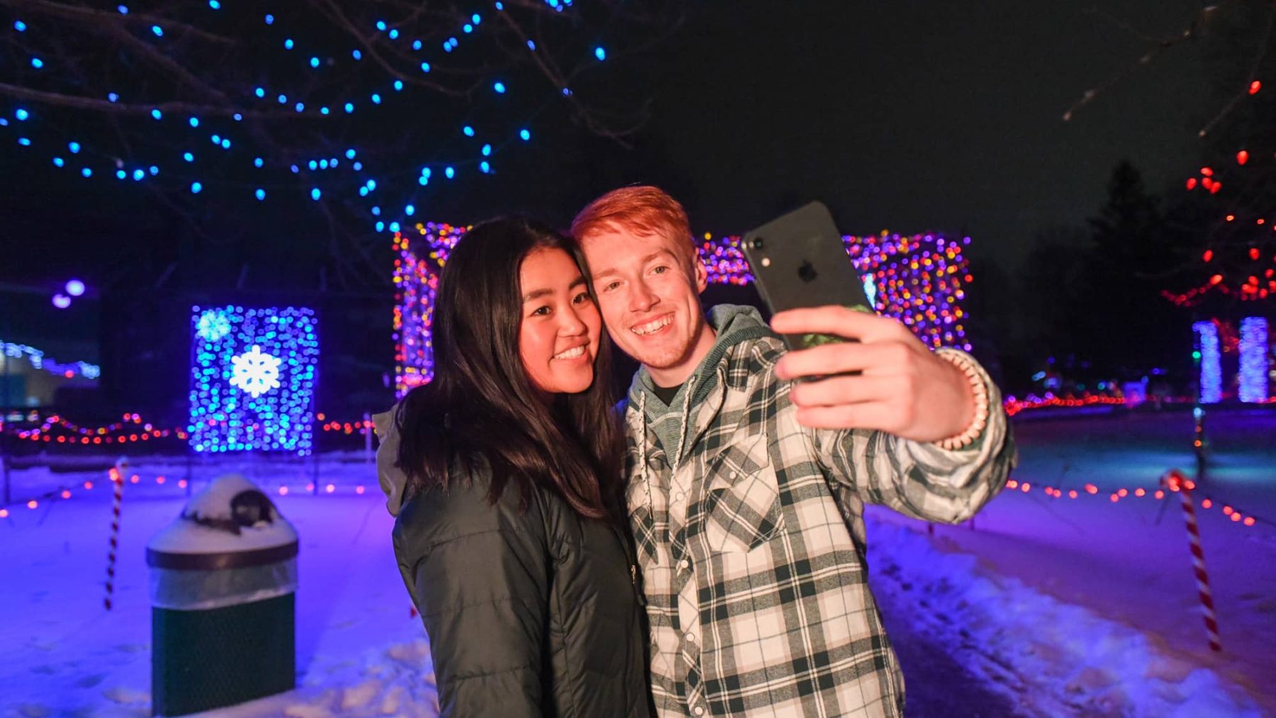 Article: Light up your holiday season with these festive displays | Couple taking a selfie at Rotary Winter Wonderland holiday light display Marshfield WI