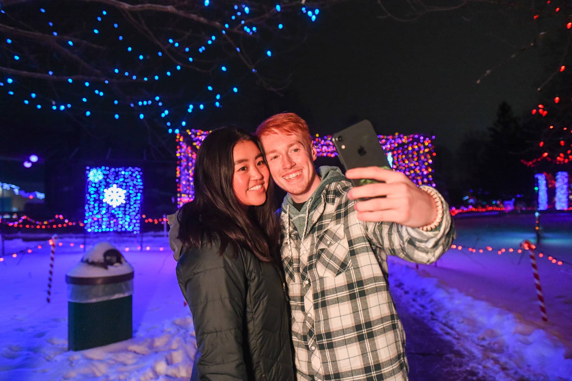 Couple taking a selfie at Rotary Winter Wonderland holiday light display Marshfield WI