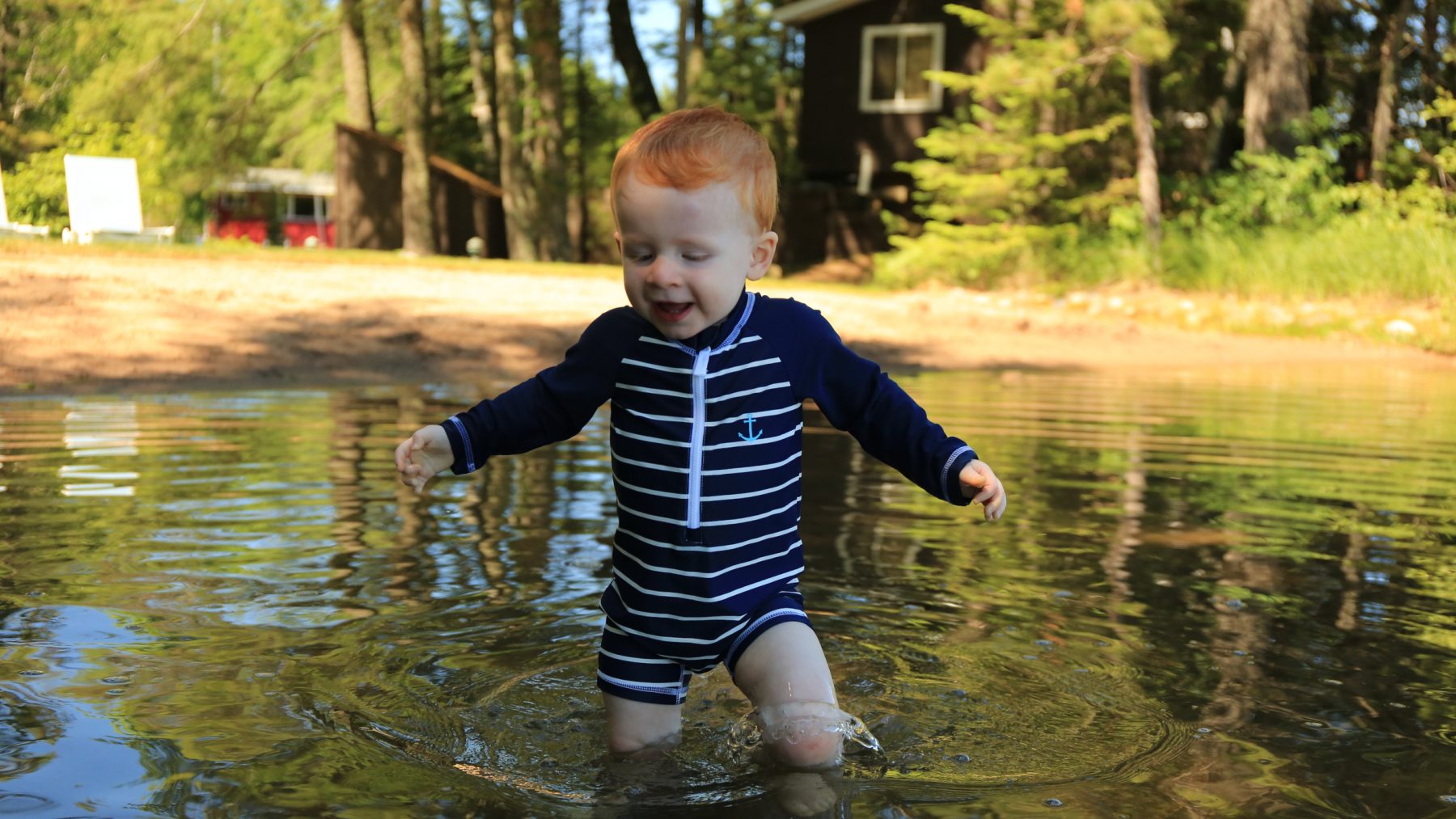 Article: Wisconsin beaches that are fun for the whole family | child swimming at beach boulder junction wi