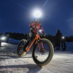 Article: Winter getaways for trail lovers | woman riding a fatbike on a winter night at the lambo zip trail in manitowoc wisconsin