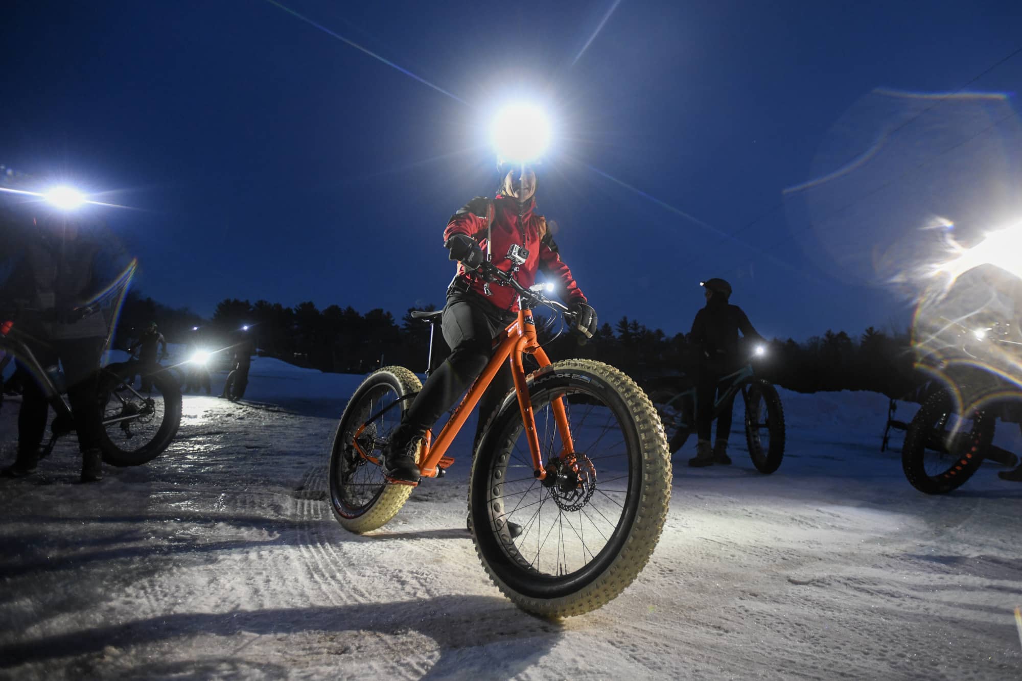 woman riding a fatbike on a winter night at the lambo zip trail in manitowoc wisconsin