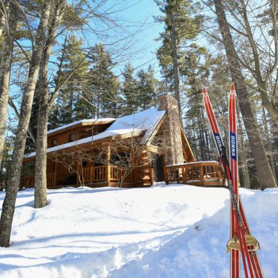 Find your Wisconsin Travel Inspiration | Book a stay at these classic Wisconsin cabins, lodges & resorts: cross-country skis in the snow outside a cabin at the beacons of minocqua in oneida county in northern wisconsin