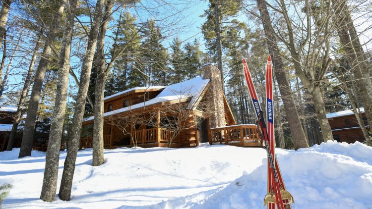 Article: Book a stay at these classic Wisconsin cabins, lodges & resorts | cross-country skis in the snow outside a cabin at the beacons of minocqua in oneida county in northern wisconsin