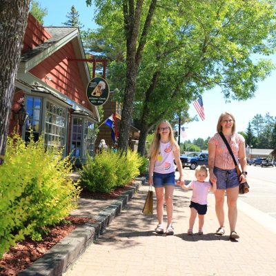 Related Article: Step into these charming sidewalk shopping destinations | mother and daughters walking on Main Street in downtown Boulder Junction Wisconsin