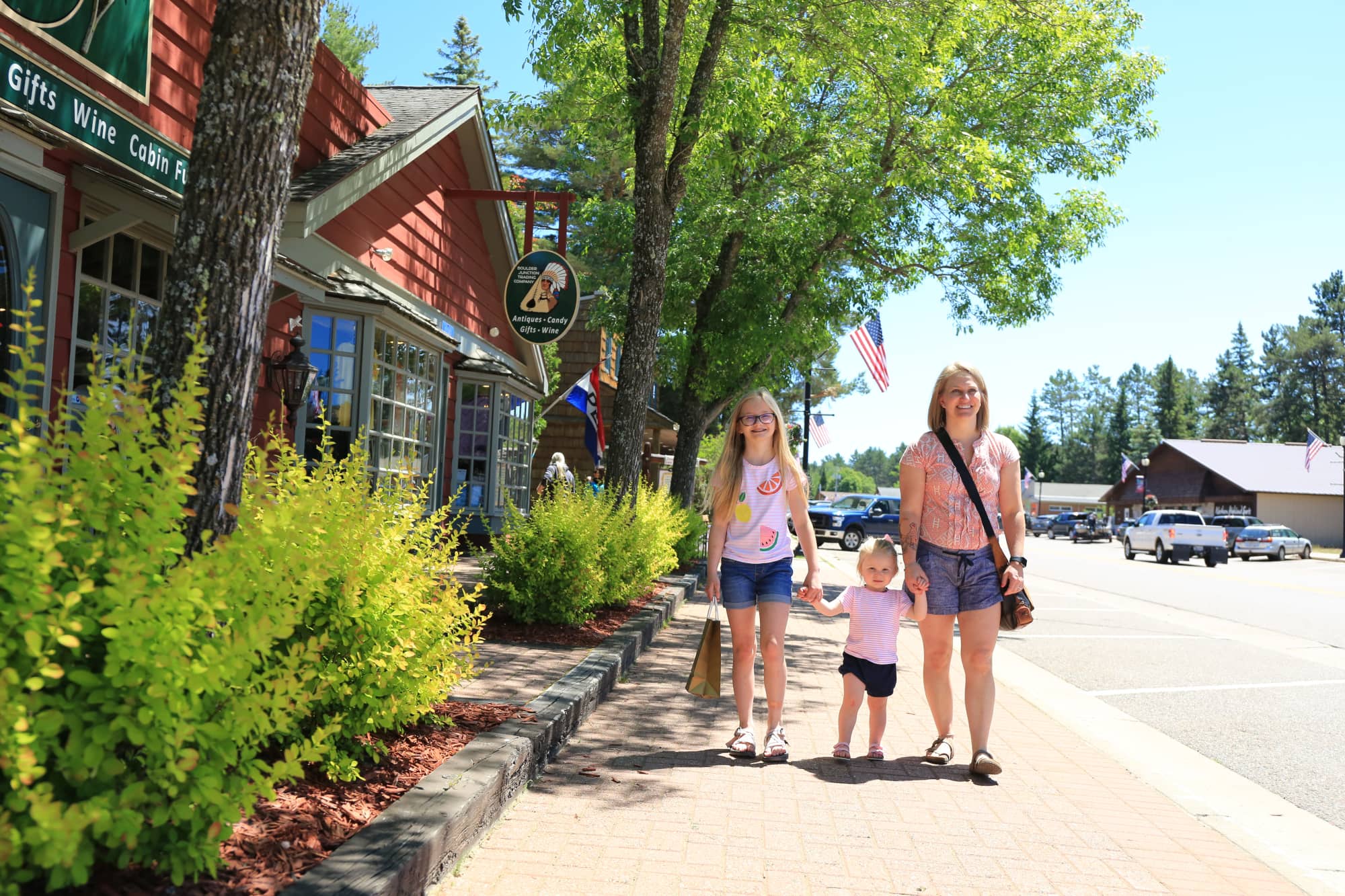 mother and daughters walking on Main Street in downtown Boulder Junction Wisconsin