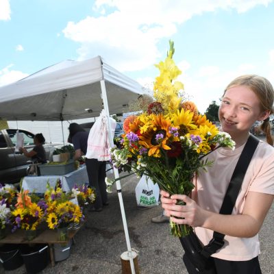 Related Article: Discover fresh finds at these farmers’ markets | girl holding bouquet of flowers at downtown tomahawk farmers market in oneida county wisconsin