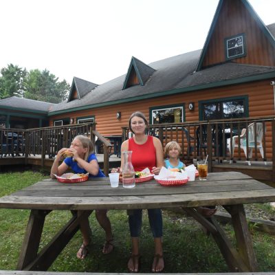 Find your Wisconsin Travel Inspiration | Amazing spots for outdoor dining & drinks in Wisconsin: Family eating outdoors at Headwaters Restaurant Boulder Junction WI