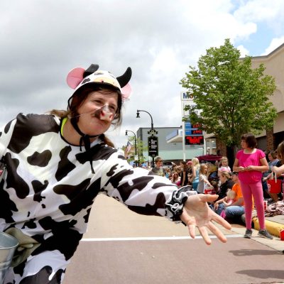 Related Article: The Big Six | Person dressed as cow throwing candy to kids during a parade