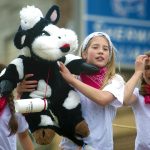 Article: What you need to know about Dairyfest | girls in parade holding stuffed cow at Dairyfest in Marshfield, WI