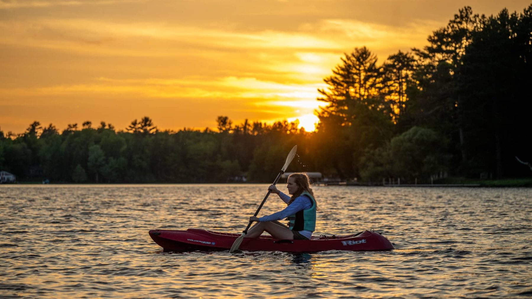 Article: Where to canoe & kayak in Wisconsin | woman kayaking at sunset on otter lake vilas county wisconsin