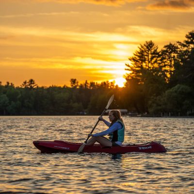 Related Article: Where to canoe & kayak in Wisconsin | woman kayaking at sunset on otter lake vilas county wisconsin