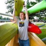 Article: Where to gear up for outdoor adventures in Wisconsin | Employee with kayaks at Coontail Adventures in Boulder Junction WI