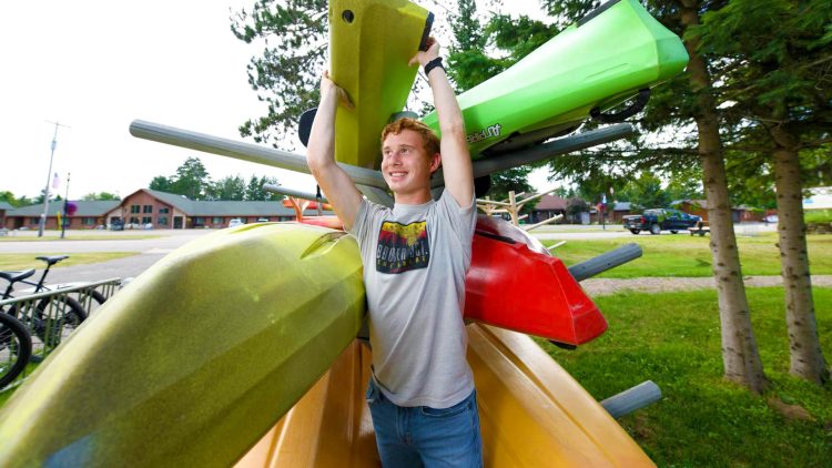 Article: Where to gear up for outdoor adventures in Wisconsin | Employee with kayaks at Coontail Adventures in Boulder Junction WI