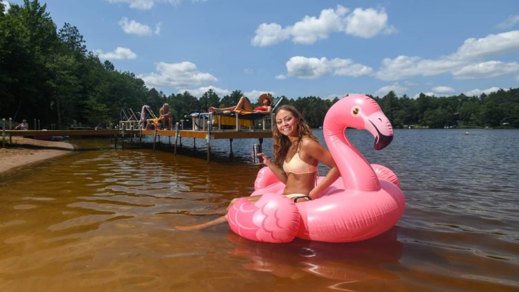 Article: Make a splash at Wisconsin’s best beaches | Girl on inflatable flamingo at beach in Oneida County Wisconsin