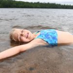 Article: Where to cool off in Wisconsin this summer | Girl swimming at Nichols Beach in Boulder Junction WI