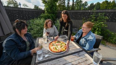 Article: Discover great dining options in Oneida County | Women eating pizza at Claytons’ 1881 Room Three Lakes Oneida County WI