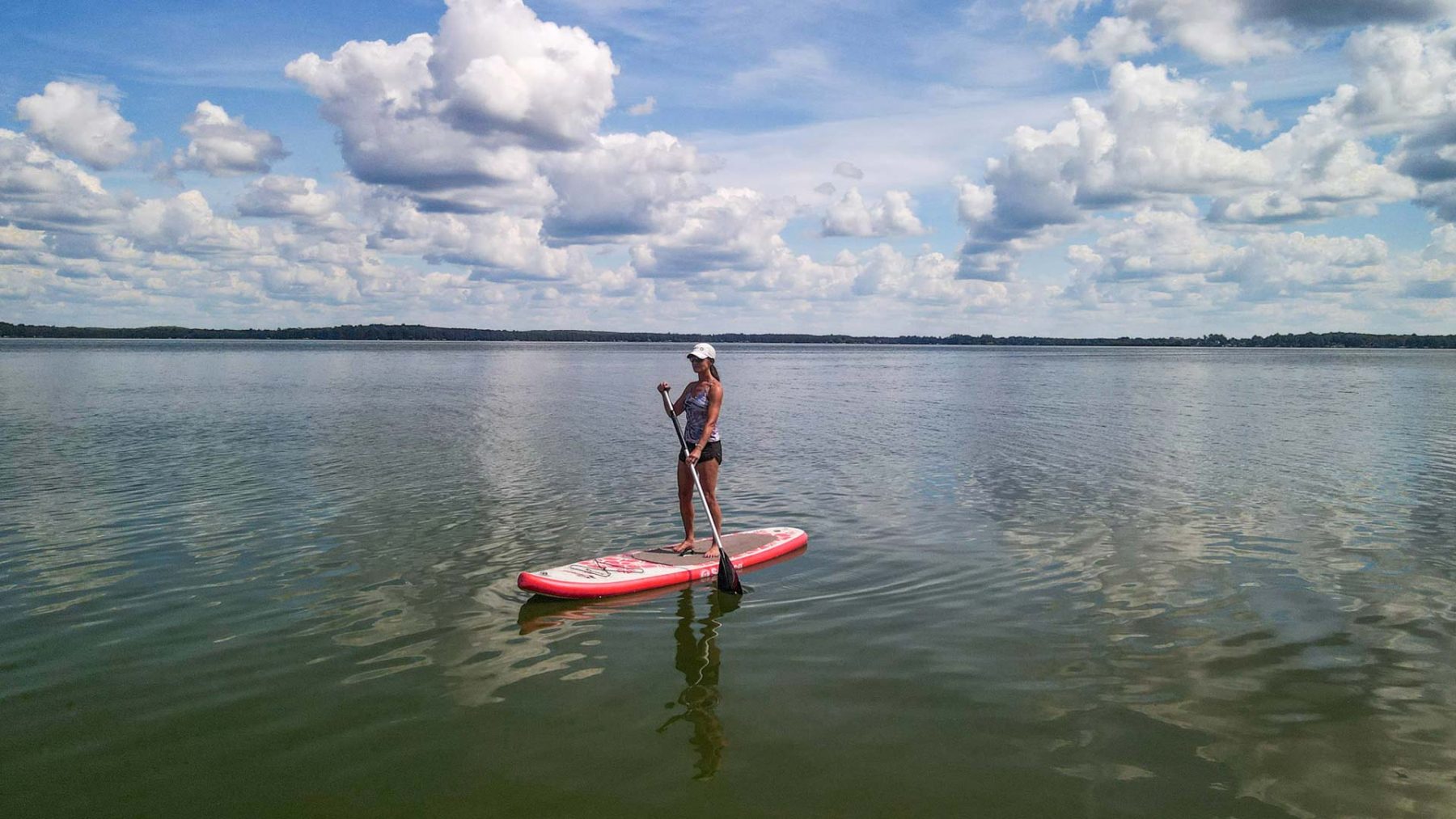 Article: Where to go canoeing & kayaking in Oneida County | Woman stand-up paddleboarding on Pelican Lake in Oneida County Wisconsin
