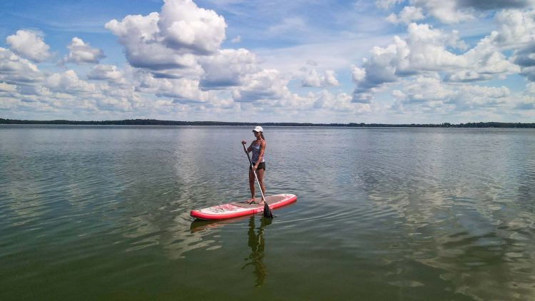 Article: Where to go canoeing & kayaking in Oneida County | Woman stand-up paddleboarding on Pelican Lake in Oneida County Wisconsin